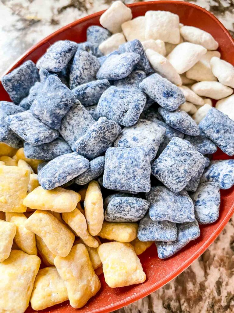 Yellow, blue, and white muddy buddies in a bowl