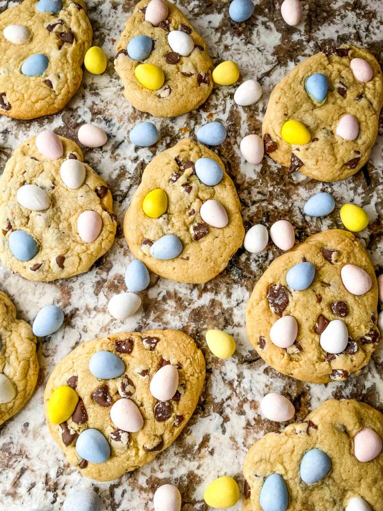 Mini Eggs Cookies spread out on a counter with mini eggs around them