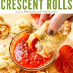 Pin of a hand dunking a Pizza Crescent Roll into sauce with title at top