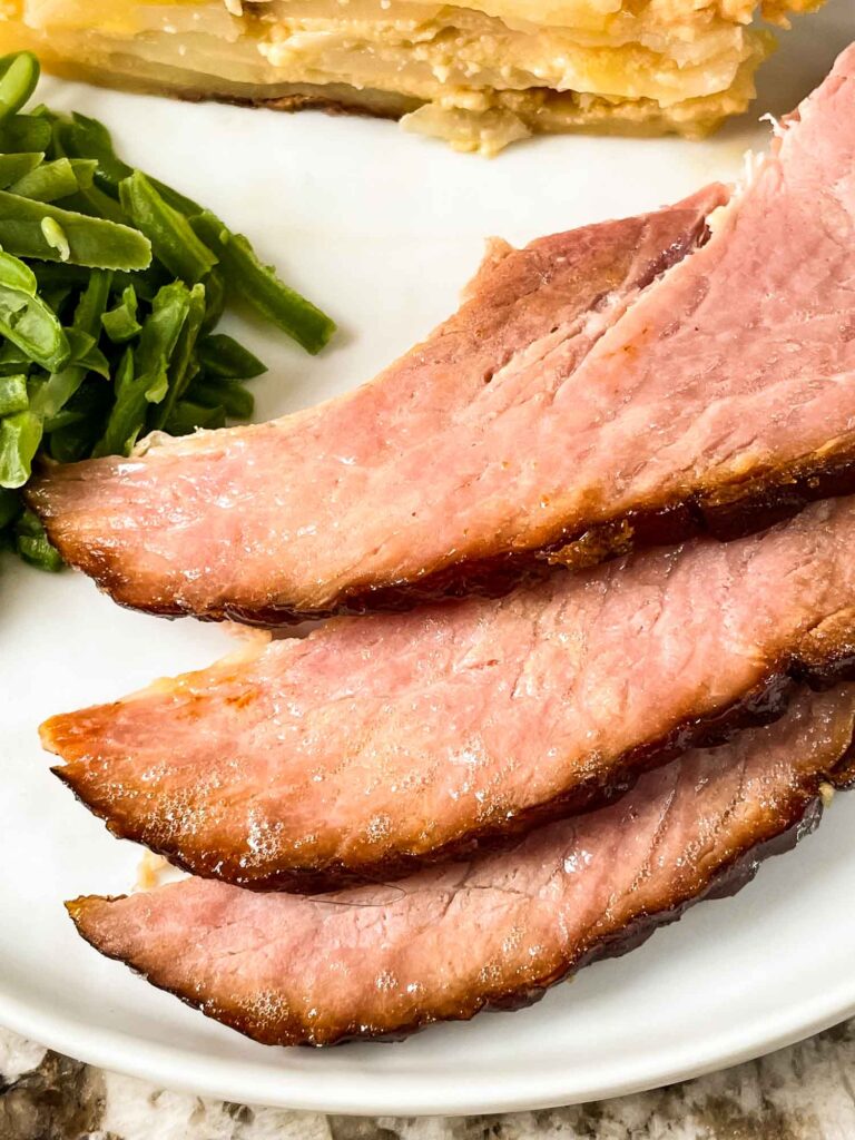 Slices of Spiral Ham with Brown Sugar Glaze on a white plate