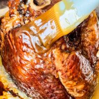 A brush basting the Spiral Ham with Brown Sugar Glaze