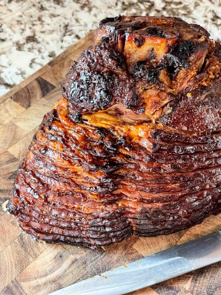 The cooked Spiral Ham with Brown Sugar Glaze on a cutting board