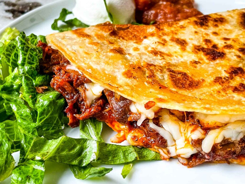 Birria Quesadilla on a white plate with lettuce