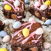 Mini Egg Brownies on a counter surrounded by chocolate mini eggs