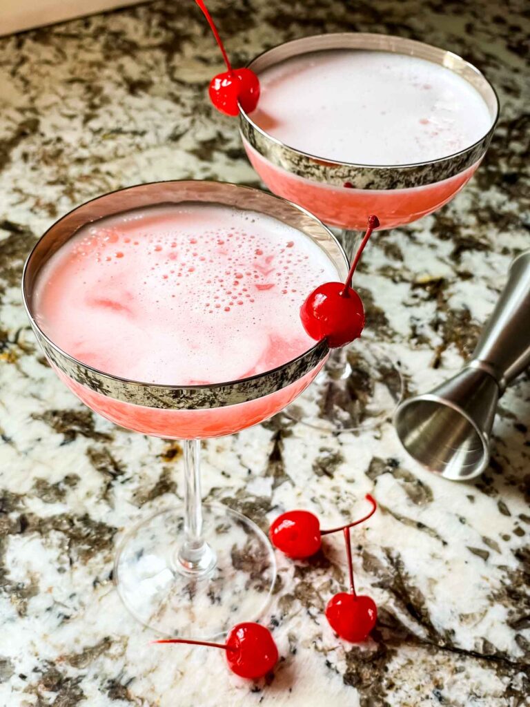 Two pink cocktails with cherries