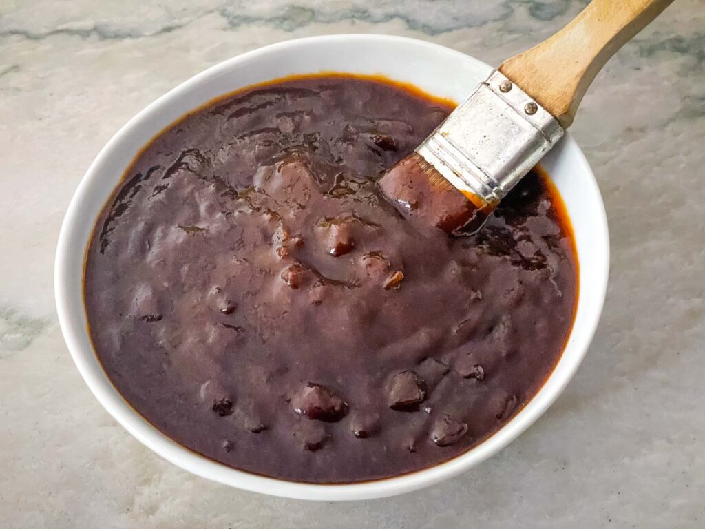 BBQ Sauce in a white bowl with a basting brush in it