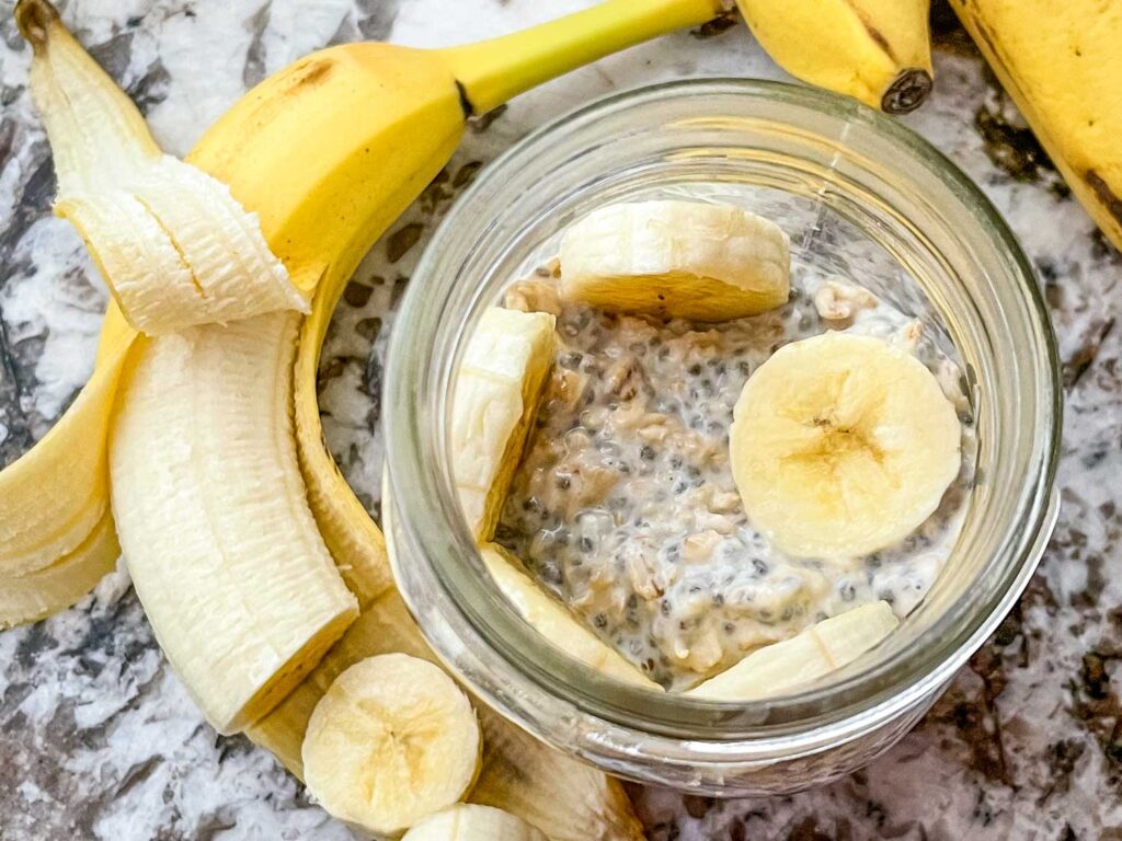 Top view of Banana Overnight Oats in a mason jar with bananas around it