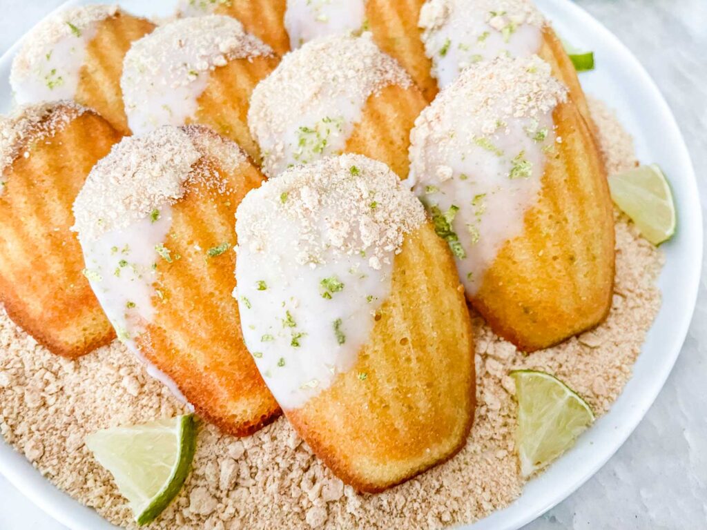 Key Lime Pie Madeleines stacked on a bed of graham cracker crumbs
