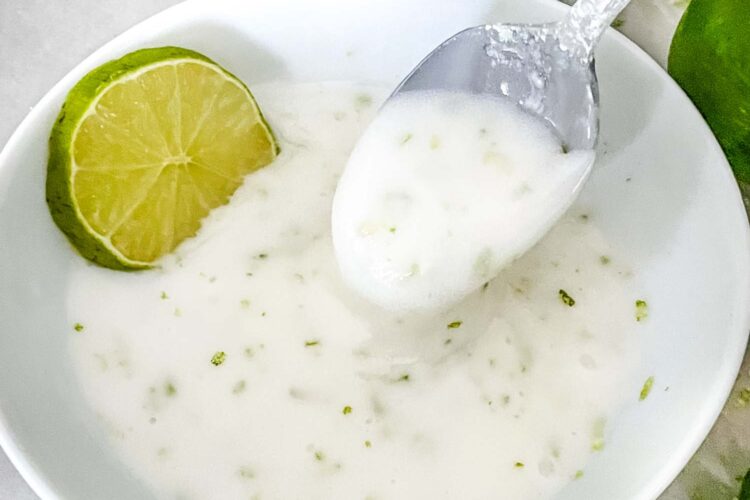 A spoon scooping Lime Glaze out of a white bowl