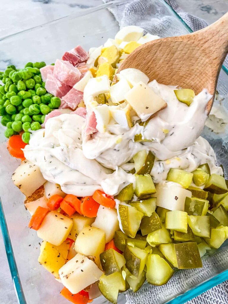 A wood spoon mixing the sauce and ingredients together