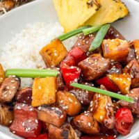 A white bowl filled with Pineapple Chicken and white rice