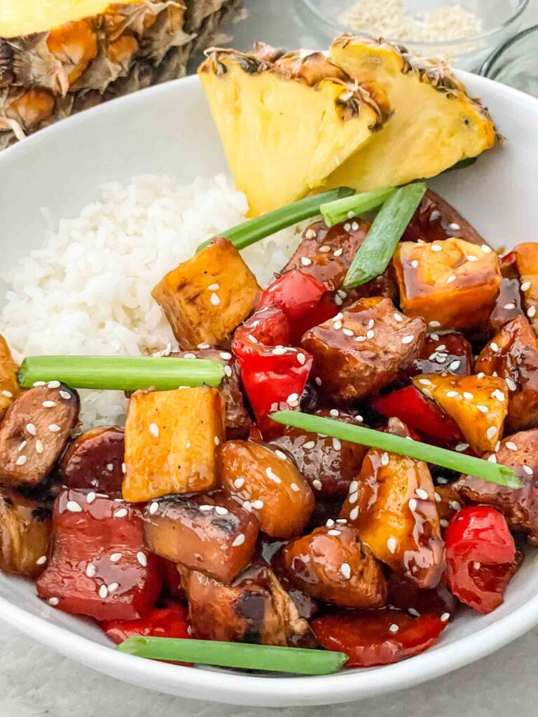 A white bowl filled with Pineapple Chicken and white rice