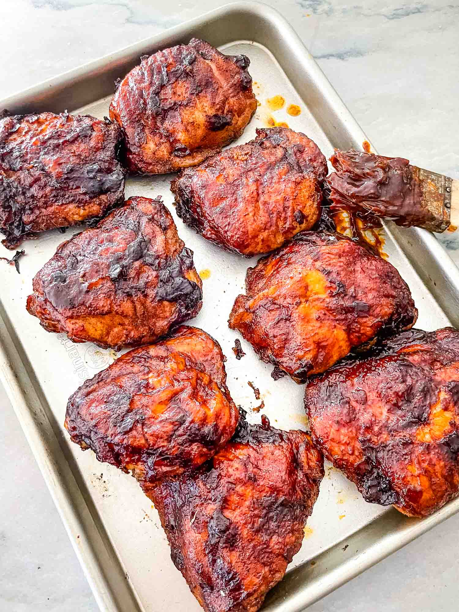 Smoked Chicken Thighs after cooking lined up on a baking sheet