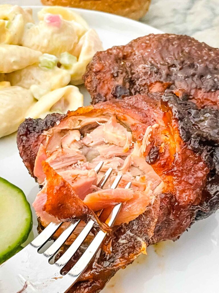 A fork digging into a Smoked Chicken Thigh