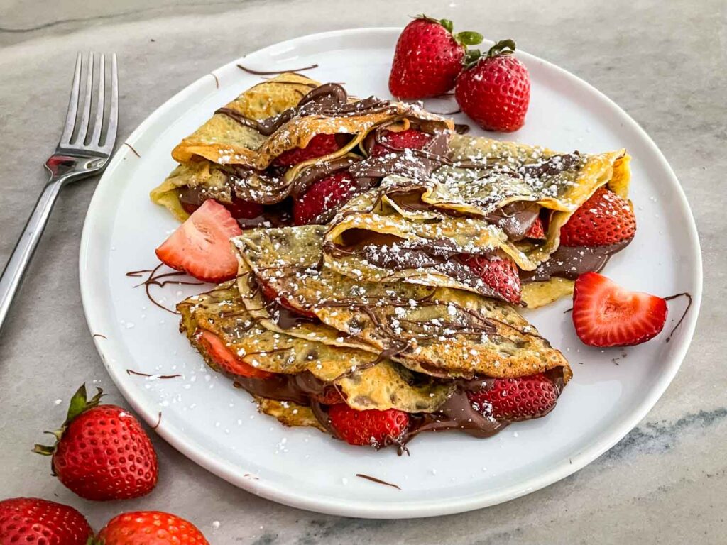 Strawberry Nutella Crepes on a white plate