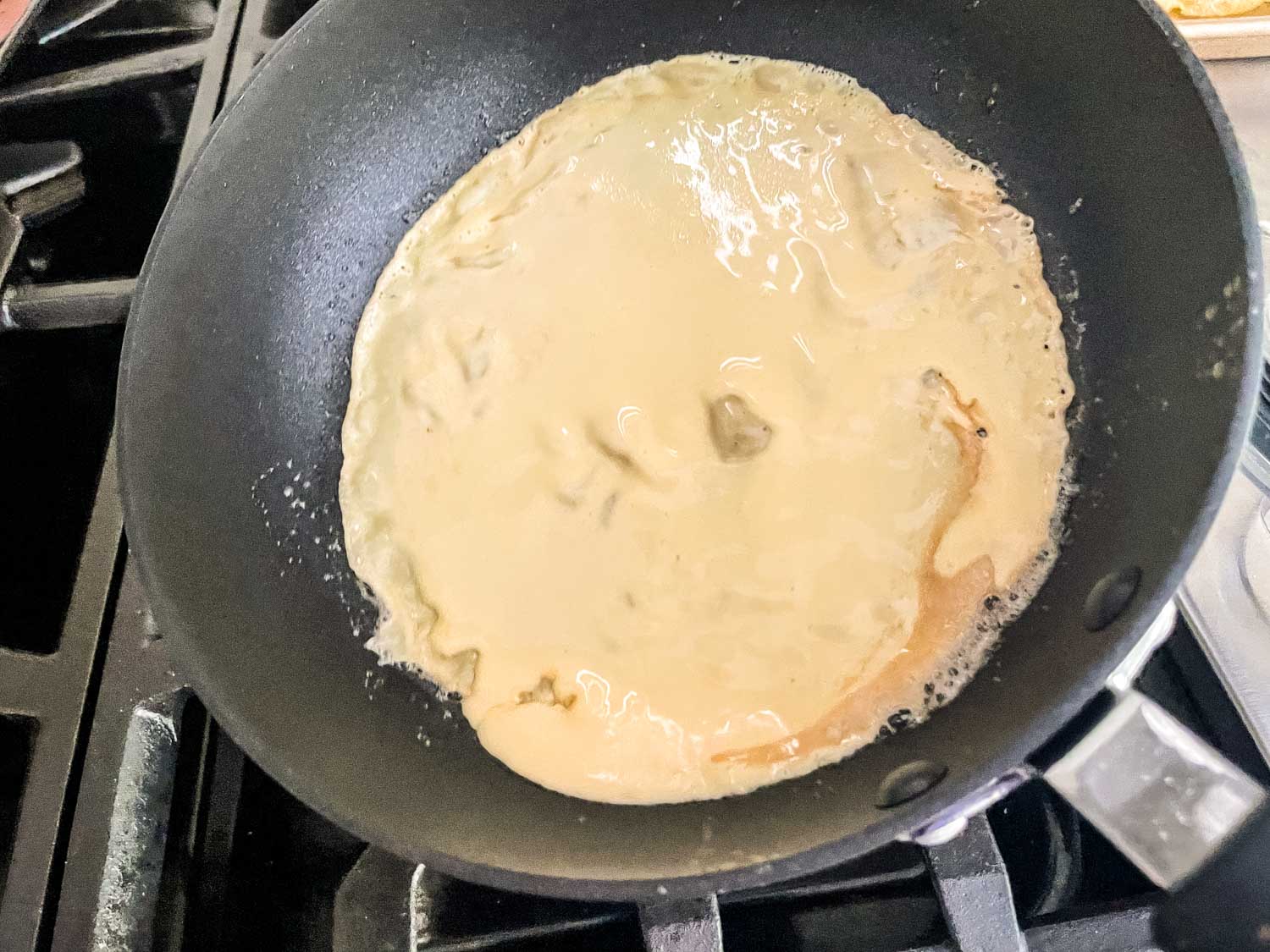 Tilt the pan around to spread out the batter and make it thin