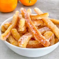 Candied Orange Peel piled up in a small bowl on a counter