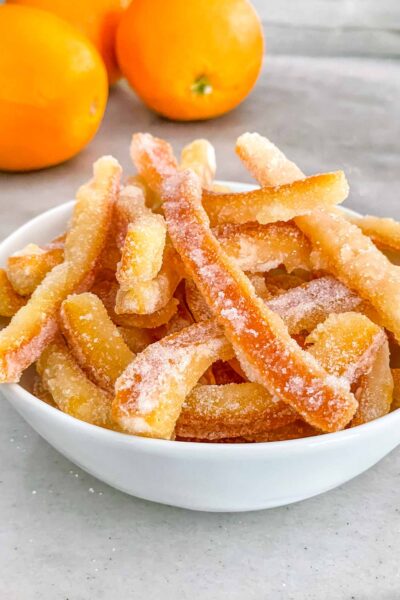 Candied Orange Peel piled up in a small bowl on a counter