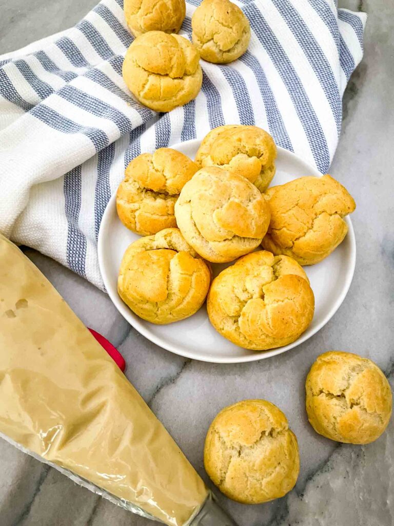 Cream Puffs scattered on a towel with pastry cream next to them