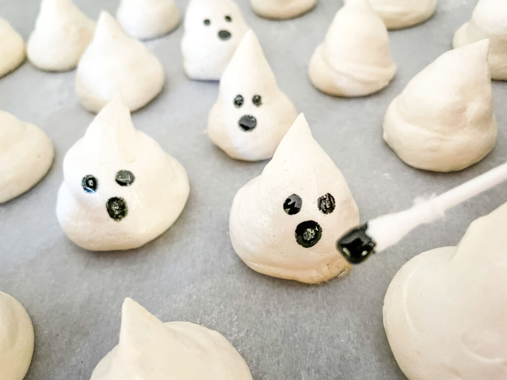 A Q tip applying faces to a meringue