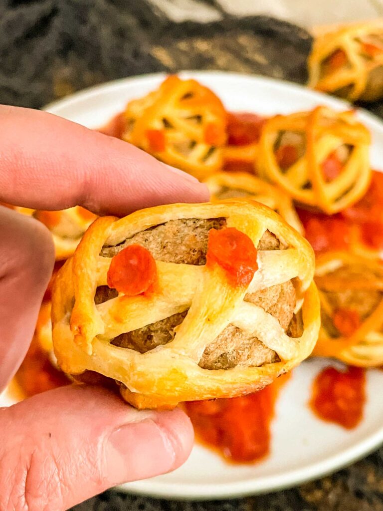 A hand holding a Halloween Mummy Meatball