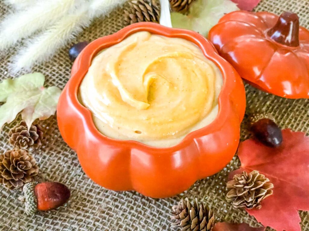 Pumpkin Pastry Cream in a pumpkin bowl surrounded by fall decor