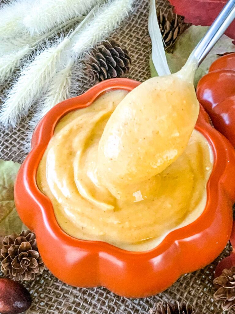 A spoon dipping into a bowl of Pumpkin Pastry Cream