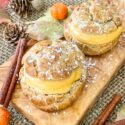 Pumpkin Spice Cream Puffs filled and on a small cutting board