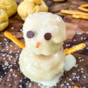 A Snowman Cream Puff on a cutting board