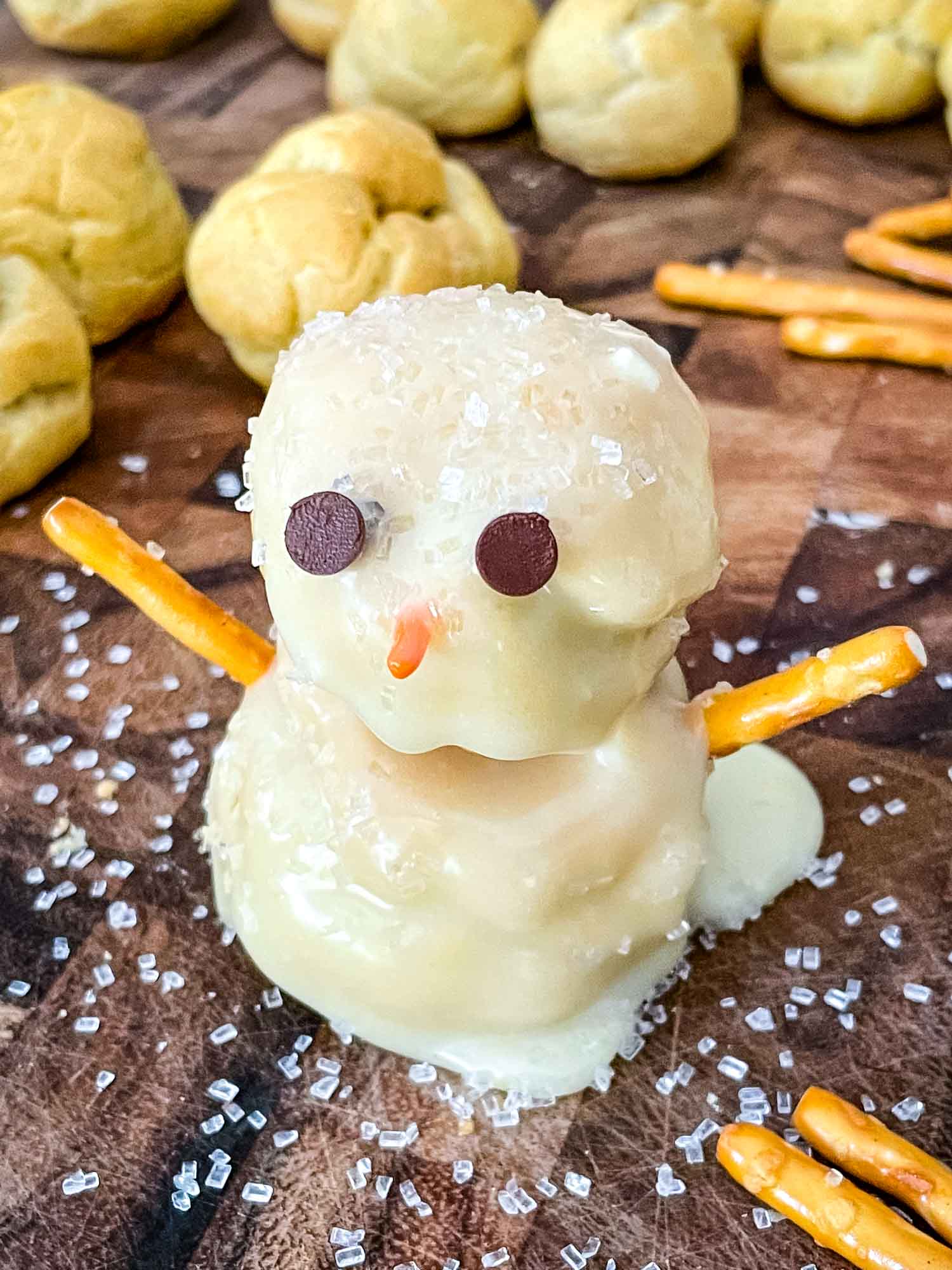 A Snowman Cream Puff on a cutting board