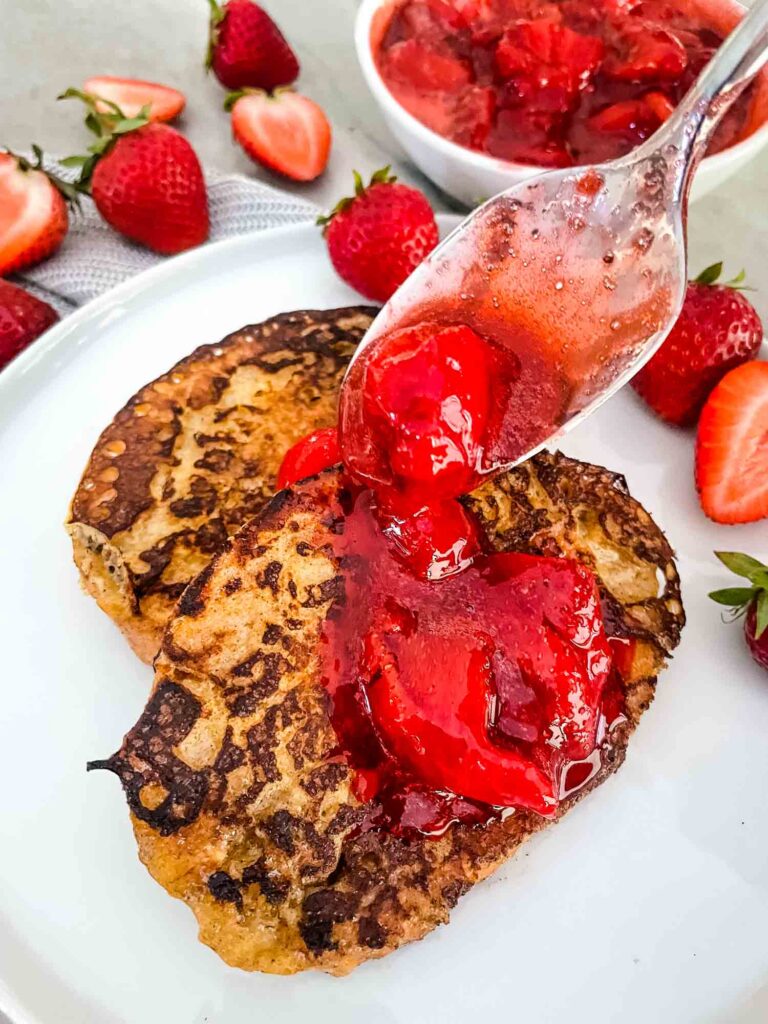 A spoon pouring the sauce on the bread