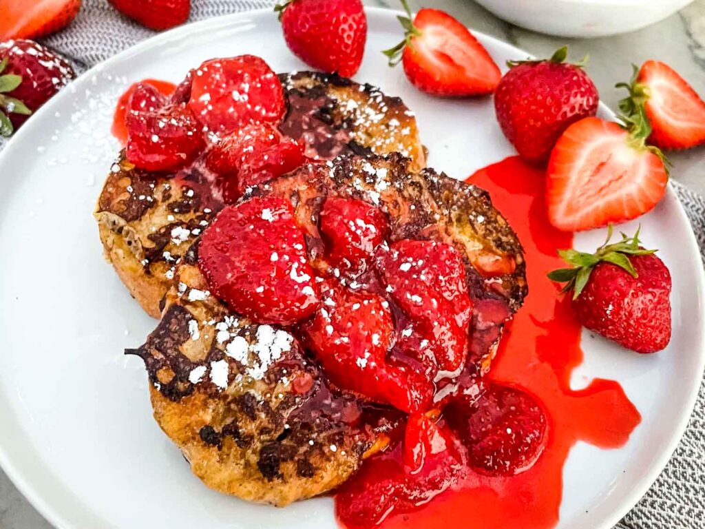 Strawberry French Toast with extra fruit on a white plate