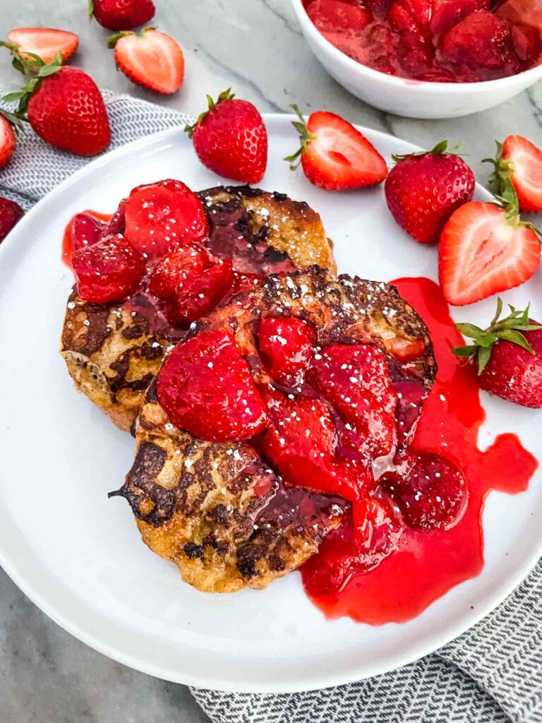 The sauce on the toast with berries around it on a plate