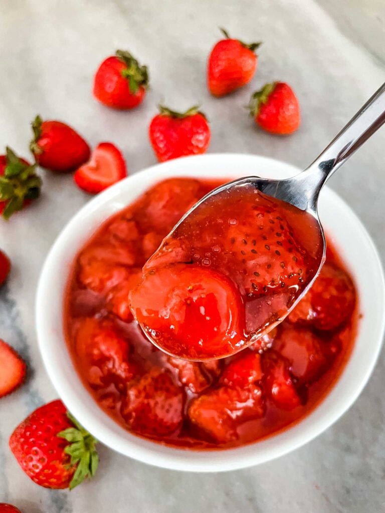 A spoon scooping into a bowl of the sauce