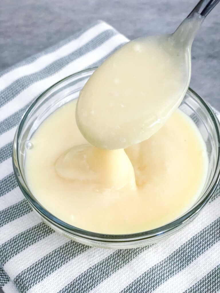 A spoon pouring the ganache into a bowl