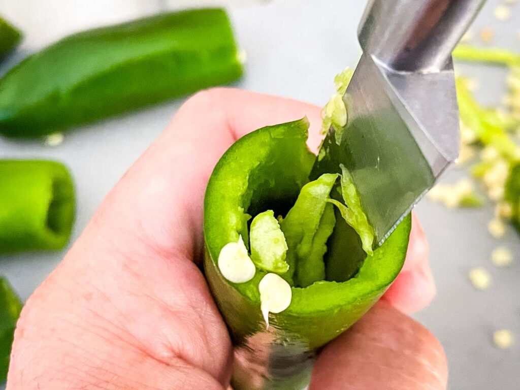 Removing the ribs and seeds from a pepper with a knife