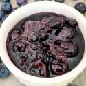 Blueberry Compote in a white dish surrounded by more fruit