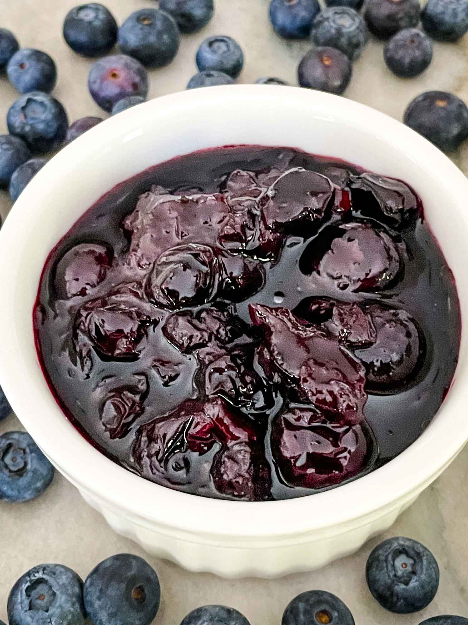 Blueberry Compote in a white dish surrounded by more fruit