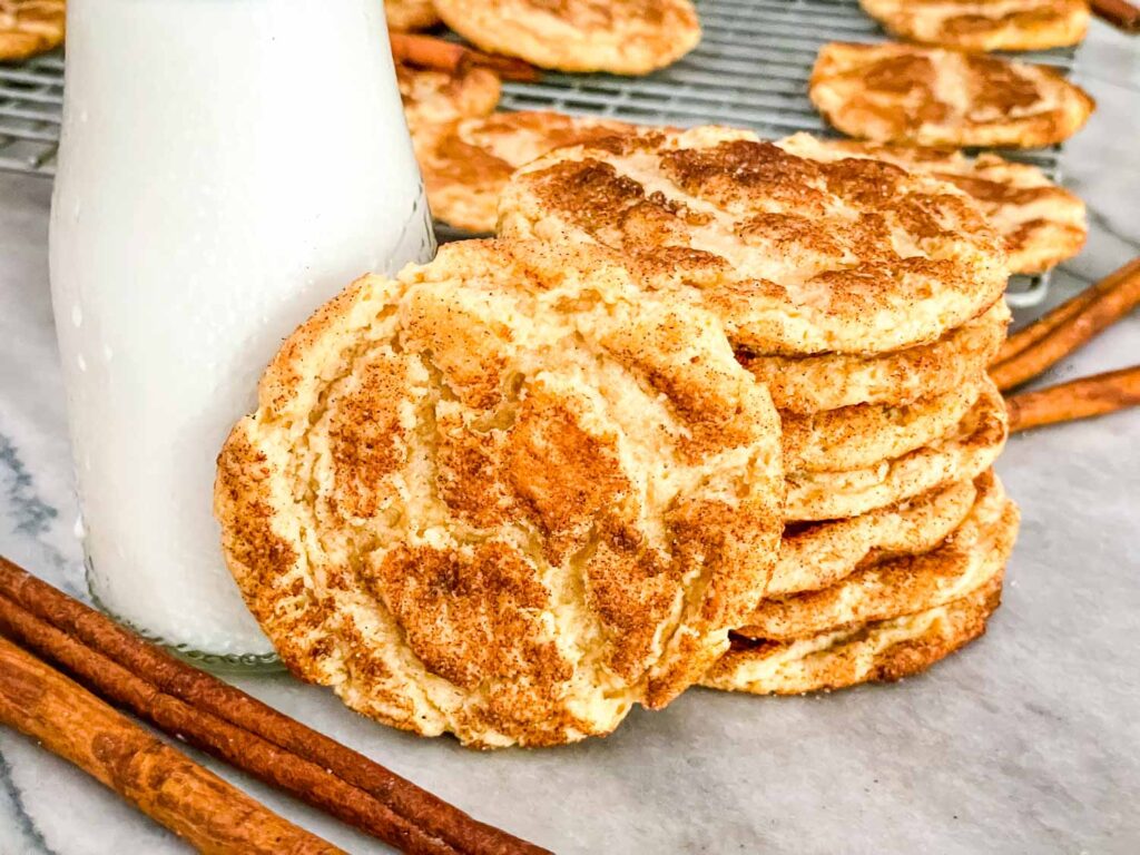 Chewy Snickerdoodle Cookies stacked next to a glass of milk