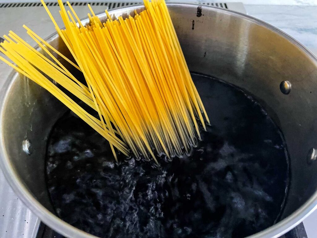 Pasta being put into black water