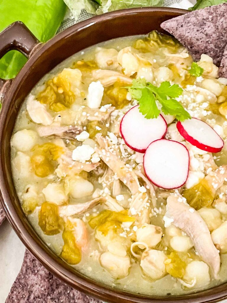 Close view of Chicken and Hatch Green Chile Pozole in a brown bowl