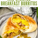 Pin of a Hatch Green Chile Sausage Breakfast Burrito cut in half on a plate with title at top