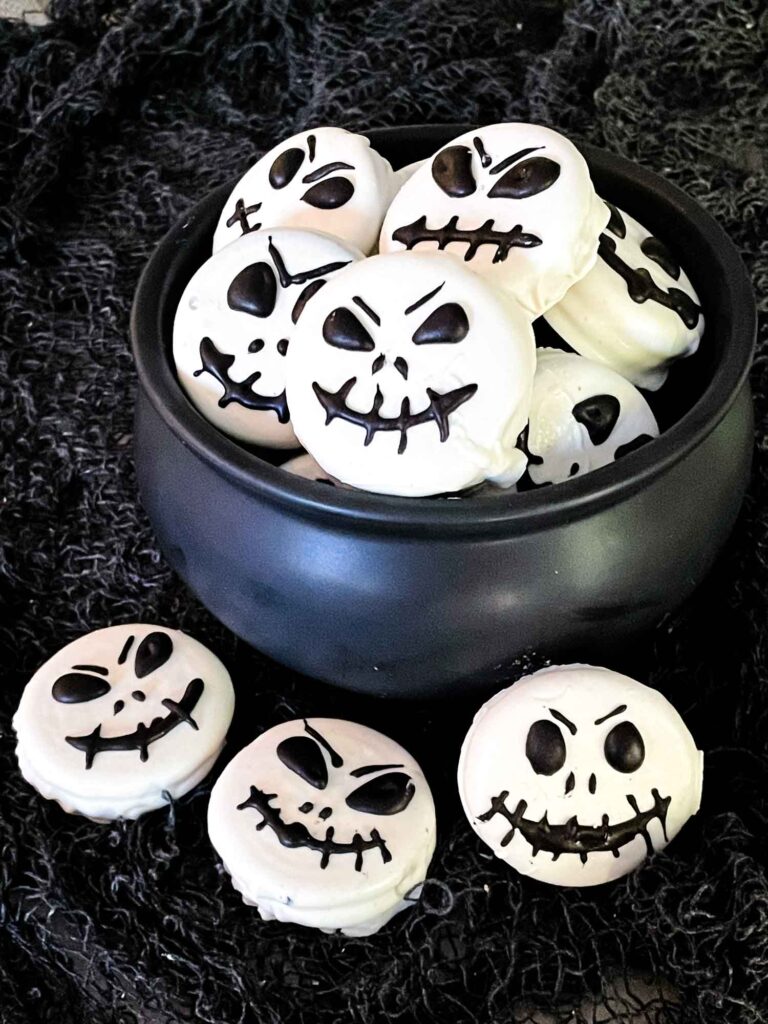 Jack Skellington Chocolate Covered Oreos in and around a small black cauldron