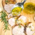 A spoon pouring sauce over sliced Rosemary Garlic Pork Tenderloin