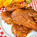 A white plate with a pile of Smoked Chicken Legs