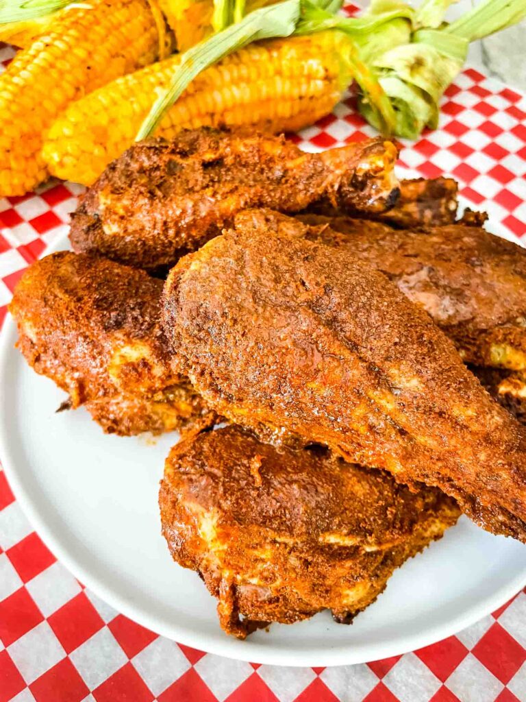 A white plate with a pile of Smoked Chicken Legs