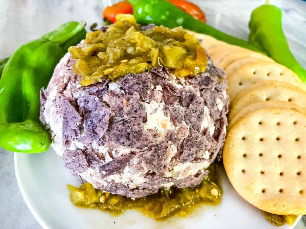 Hatch Green Chile Cheese Ball on a plate with crackers and peppers