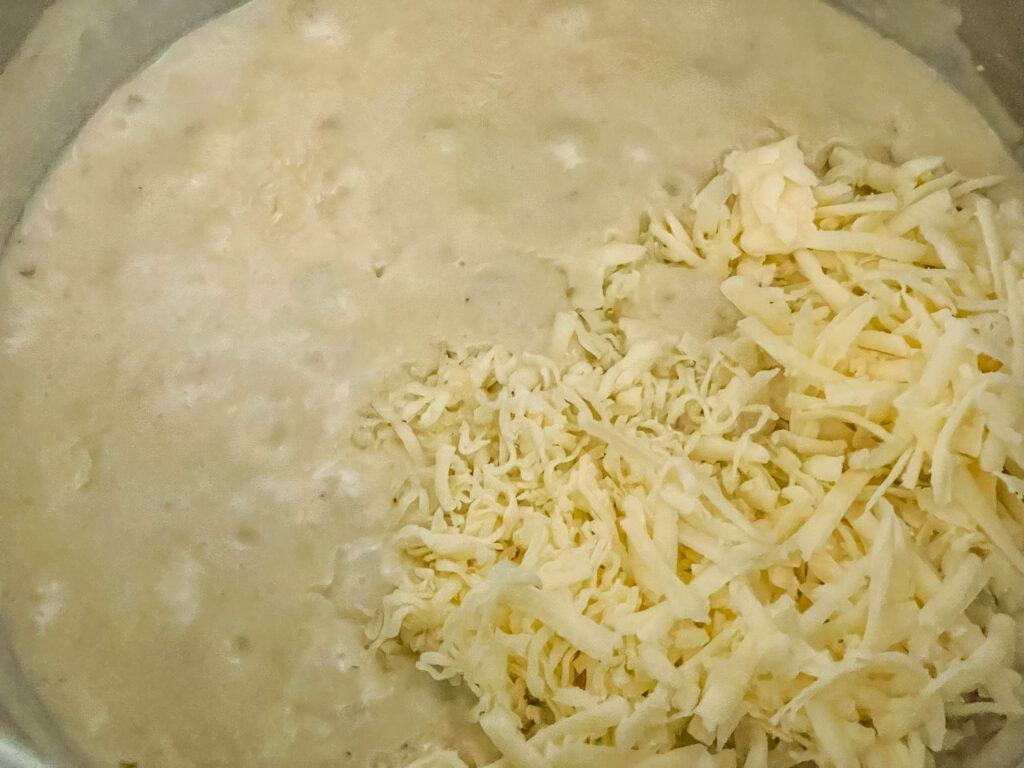 The cheese being added to the sauce