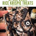 Pin of a hand holding a Hocus Pocus Spell Book Rice Krispie Treat with title at top