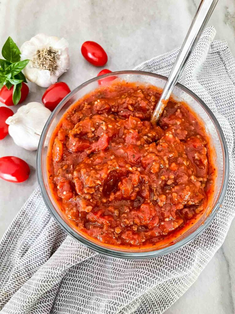 Meat Sauce in a glass bowl with a spoon in it on a counter